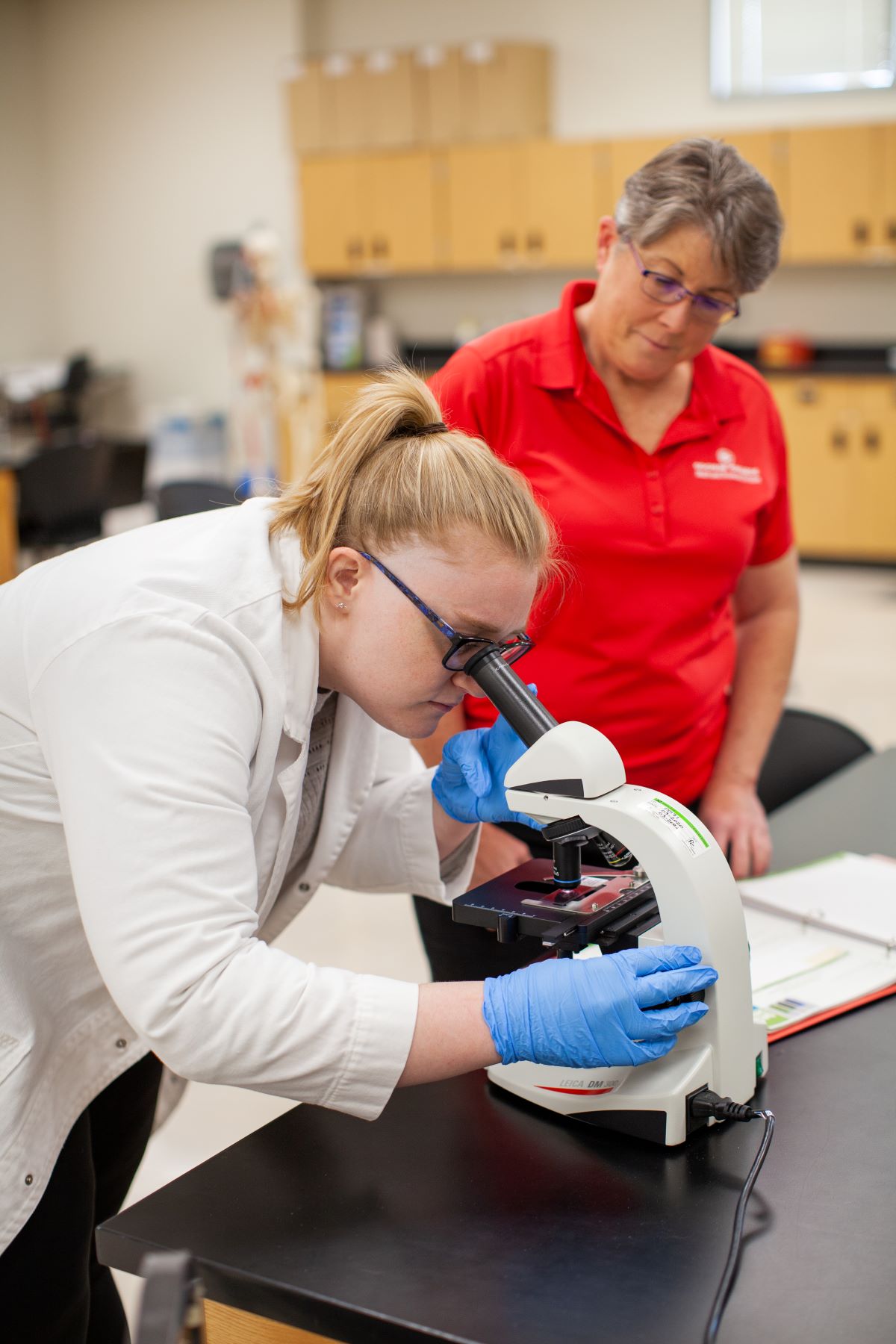 biology student looking through microscope