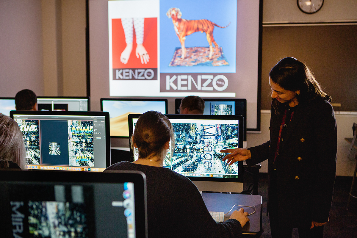 Instructor with students at their computers designing graphics