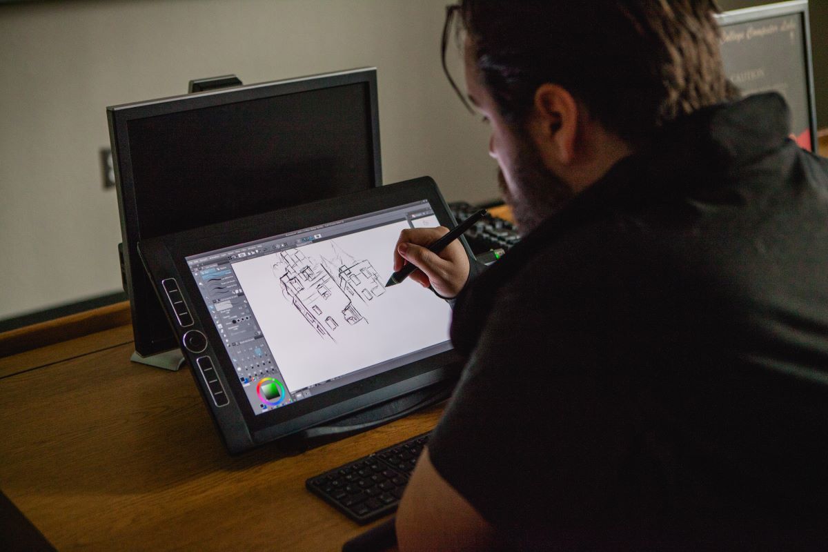 male student drawing on tablet